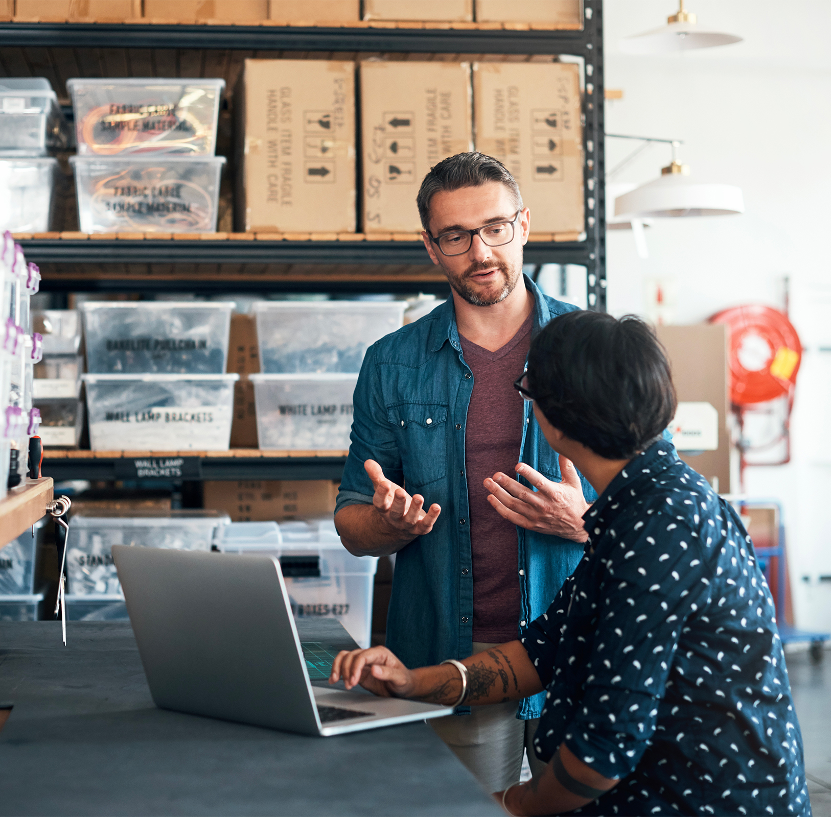 Un entrepreneur qui explique des consignes à son employé dans un entrepôt